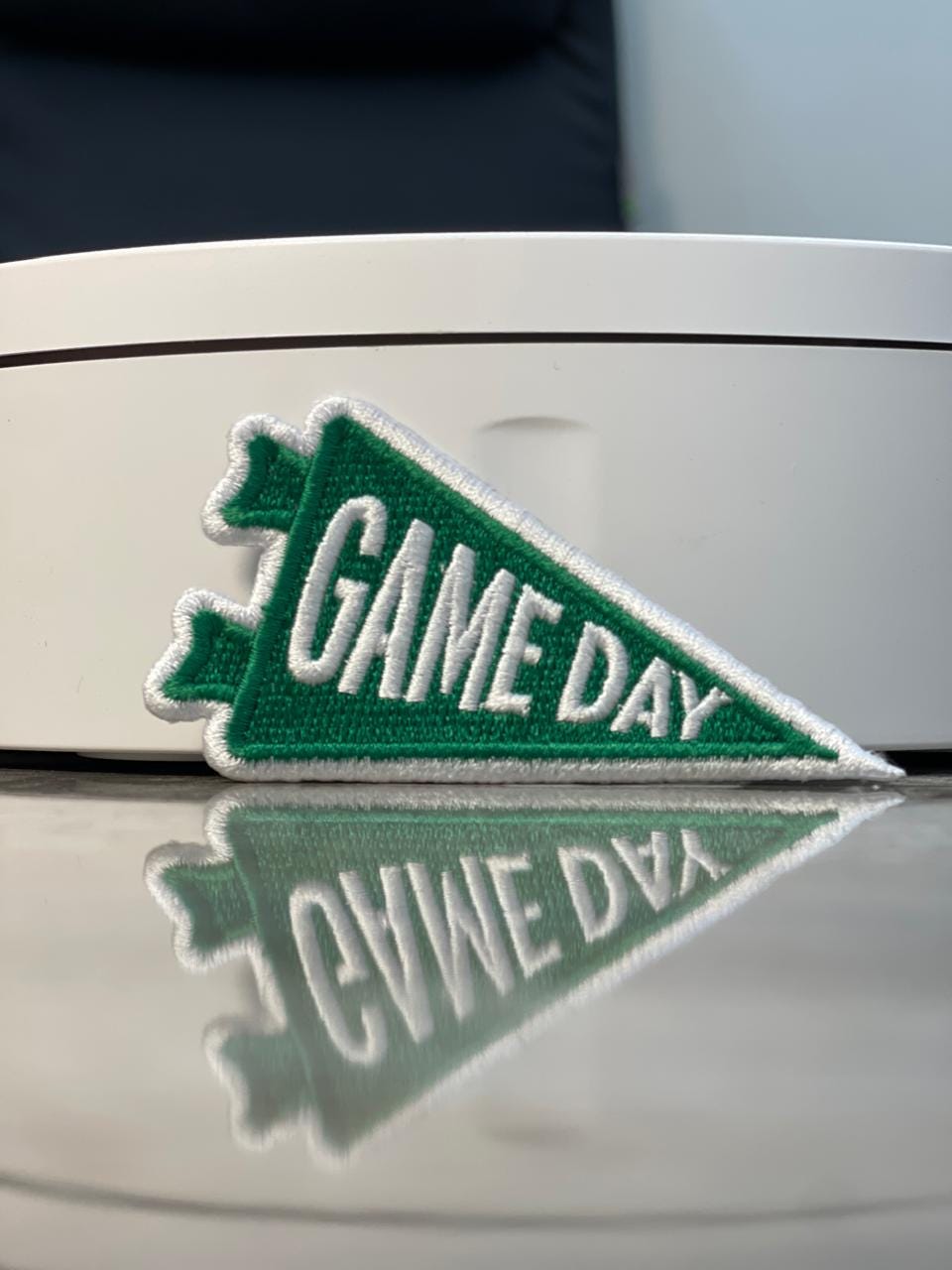 Green Game Day pennant embroidered patch shown on a display box, custom sports embroidery patch.