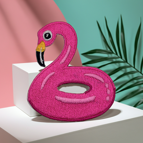 Pink flamingo-shaped pool float on a white block with a green and pink background
